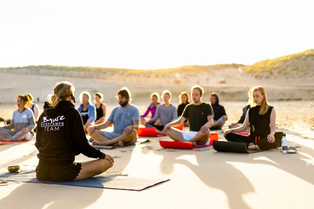 Yoga session am Strand nach dem surfen